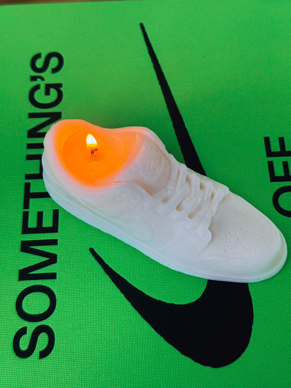 Makagi Sneaker Kerze nike Dunk weiß brennend auf grünem buch