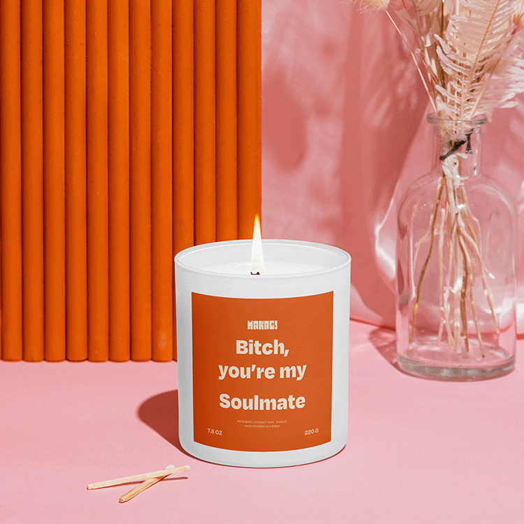 Makagi Duftkerze mit Bitch you're my soulmate stehend auf rosa Hintergrund mit Streichhölzern davor und Vase im Hintergrund